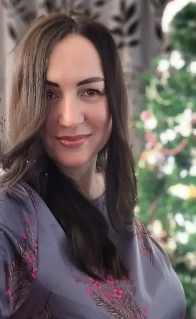 Woman smiling with blurred festive background.