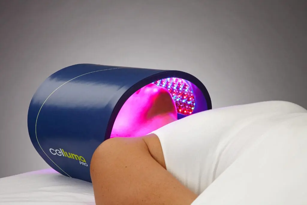 Person under LED light therapy device. Person under LED light therapy device.