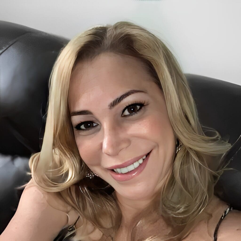 Smiling blonde woman in a chair.
