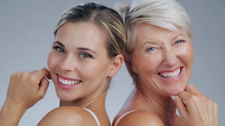 Two women smiling back to back.