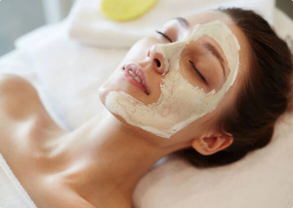 Woman with facial mask relaxing at spa.