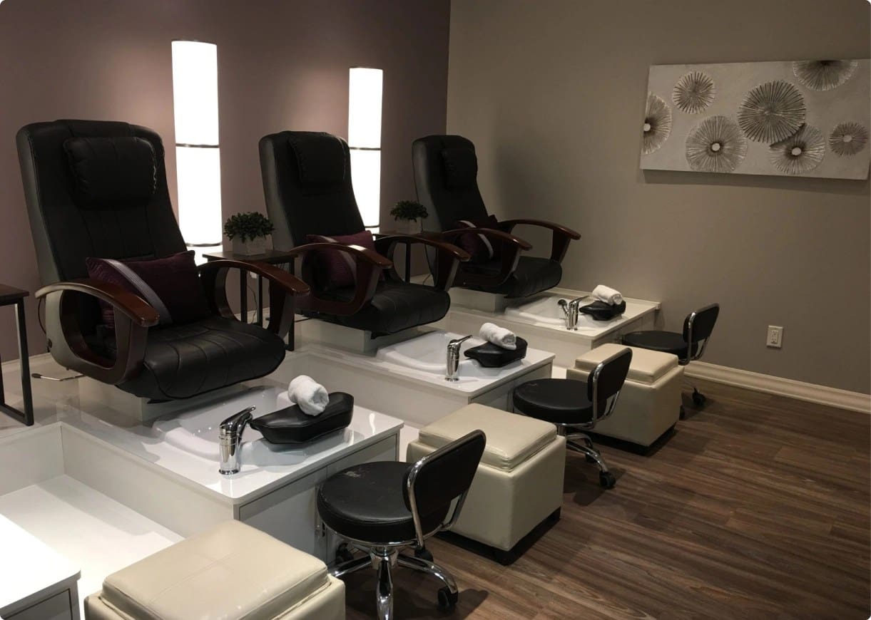 Three luxurious pedicure chairs in a spa.