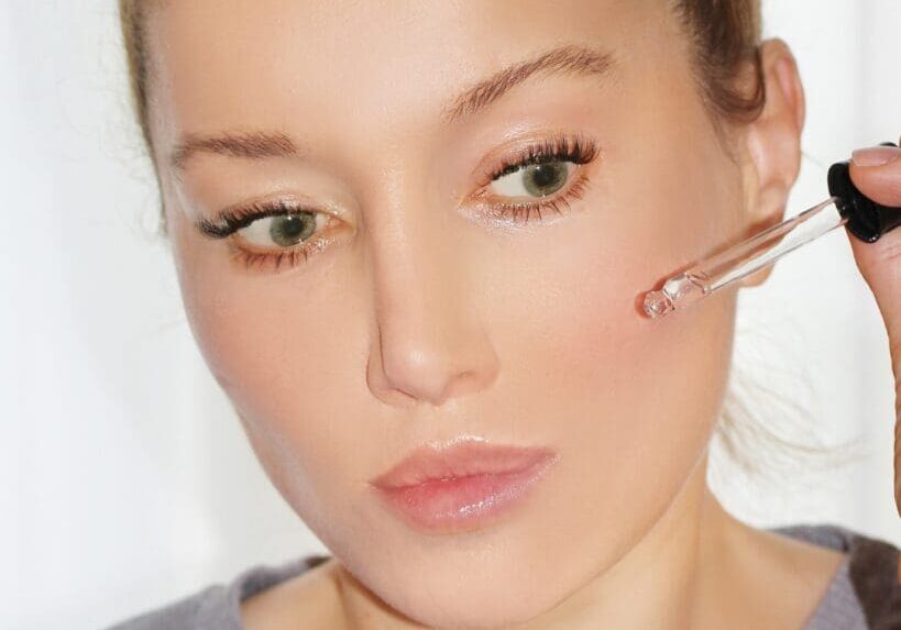 Close-up of woman applying serum to her face